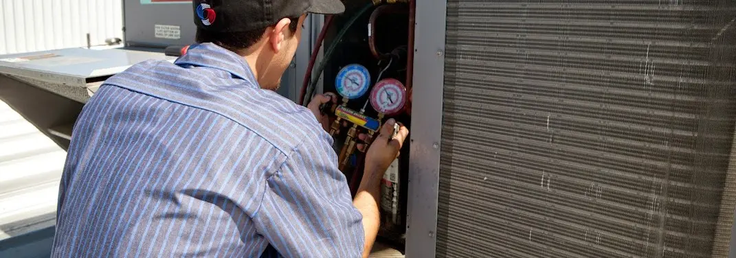 HVAC technician servicing a condenser unit in Brook Park