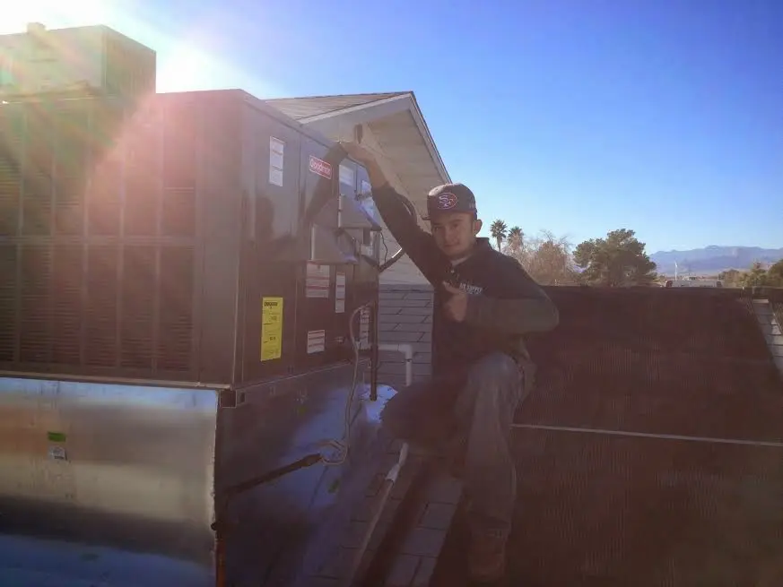 HVAC technician performing AC Tune-Up on a rooftop unit in Brook Park